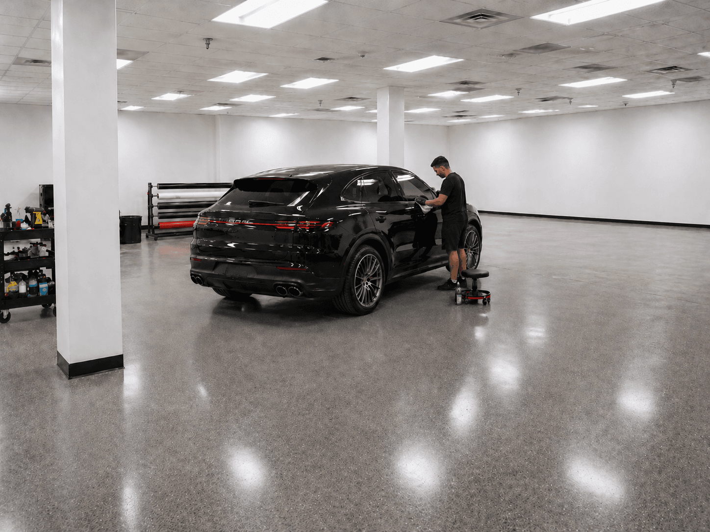 Technician detailing a black SUV